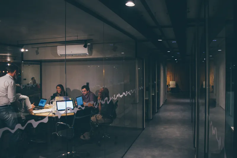 Teams collaborating in a modern glass-walled office